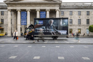 A giant 'Postcard With An Edge' adorns the side of a truck parked at the GPO on Dublin's O'Connell Street. It depicts an older man sitting, alone and sad on the edge of a bed. Caption reads: For you it is care, For him it is custody.